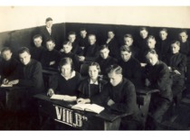 Pupils of the 8b grade of the Rygi&scaron;kiai Jonas Gymnasium with their class teacher M. Katilius,1935. V. Jasiukevičius is the 1st from the left in the second row of desks (family archive of L. Kudarienė)