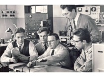Prof. K. Bar&scaron;auskas with doctoral students at the Ultrasound Problem Laboratory, 1964. In the photograph (from the left): J. Vosylius, S. Mickūnas, Prof. K. Bar&scaron;auskas, R. Krivickas, standing - V. Ambrasas. (the original photograph is at KTU Museum)